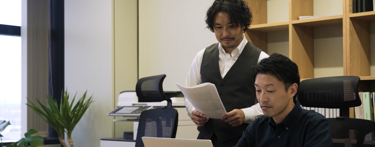 株式会社カイトリエ代表取締役とパソコンを操作するスタッフ